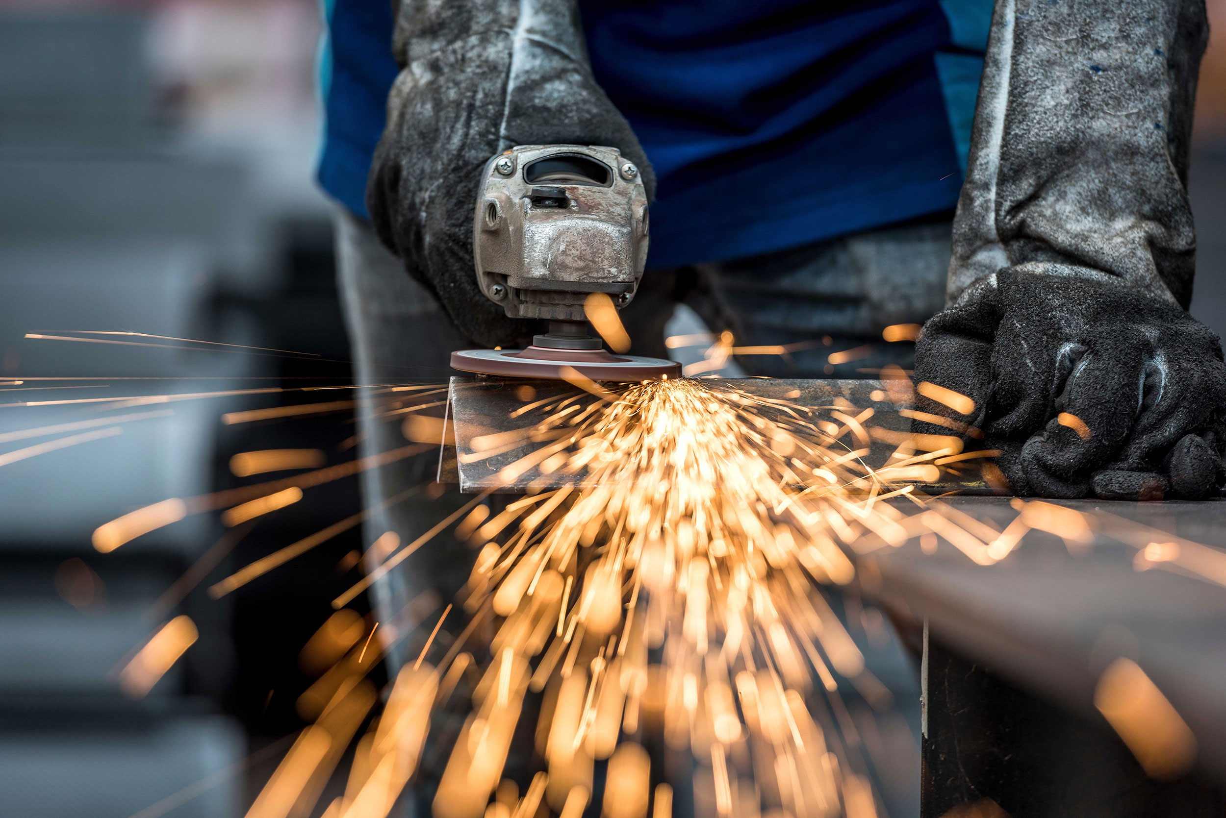 Sparks fly from a hand-held angle grinder