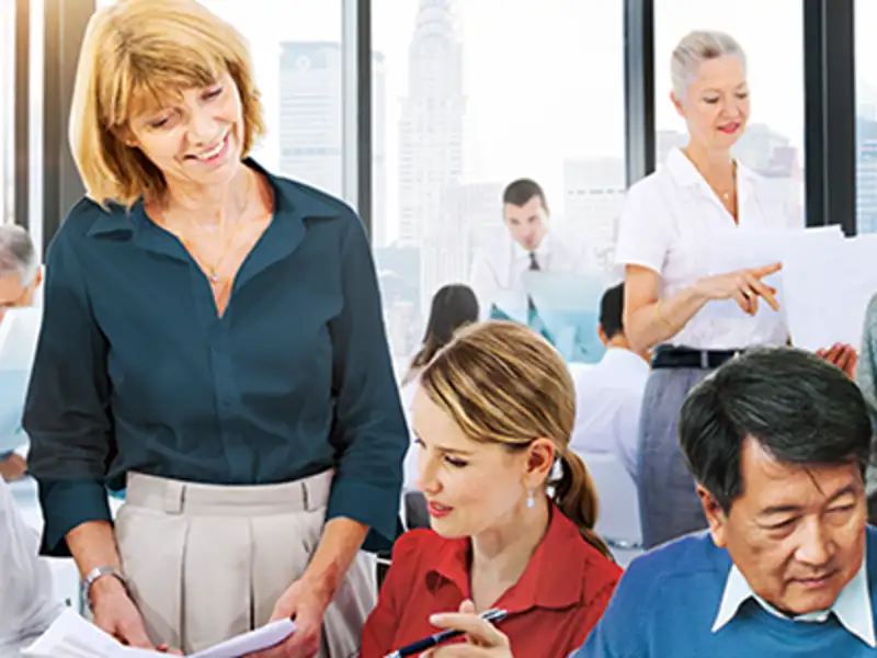 Coworkers talking, looking over one another at a casual meeting.