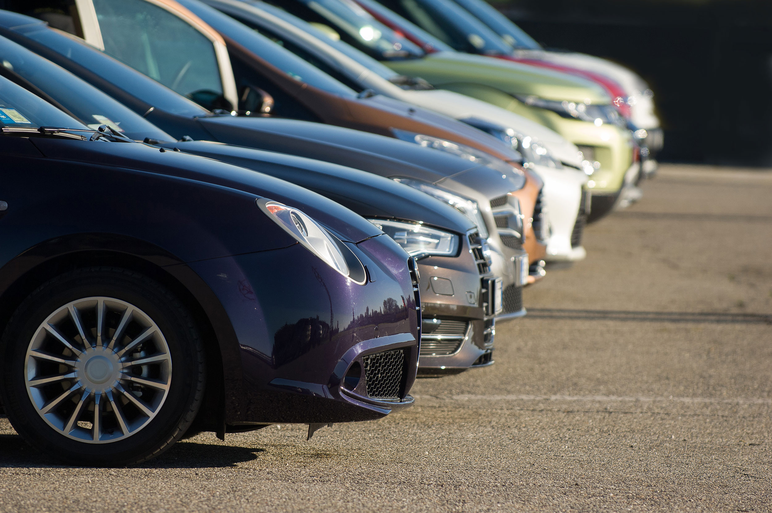Looking down the front of a row of passenger vehicles